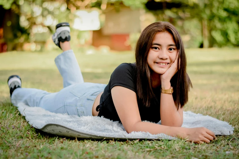 a girl laying on a blanket in the grass