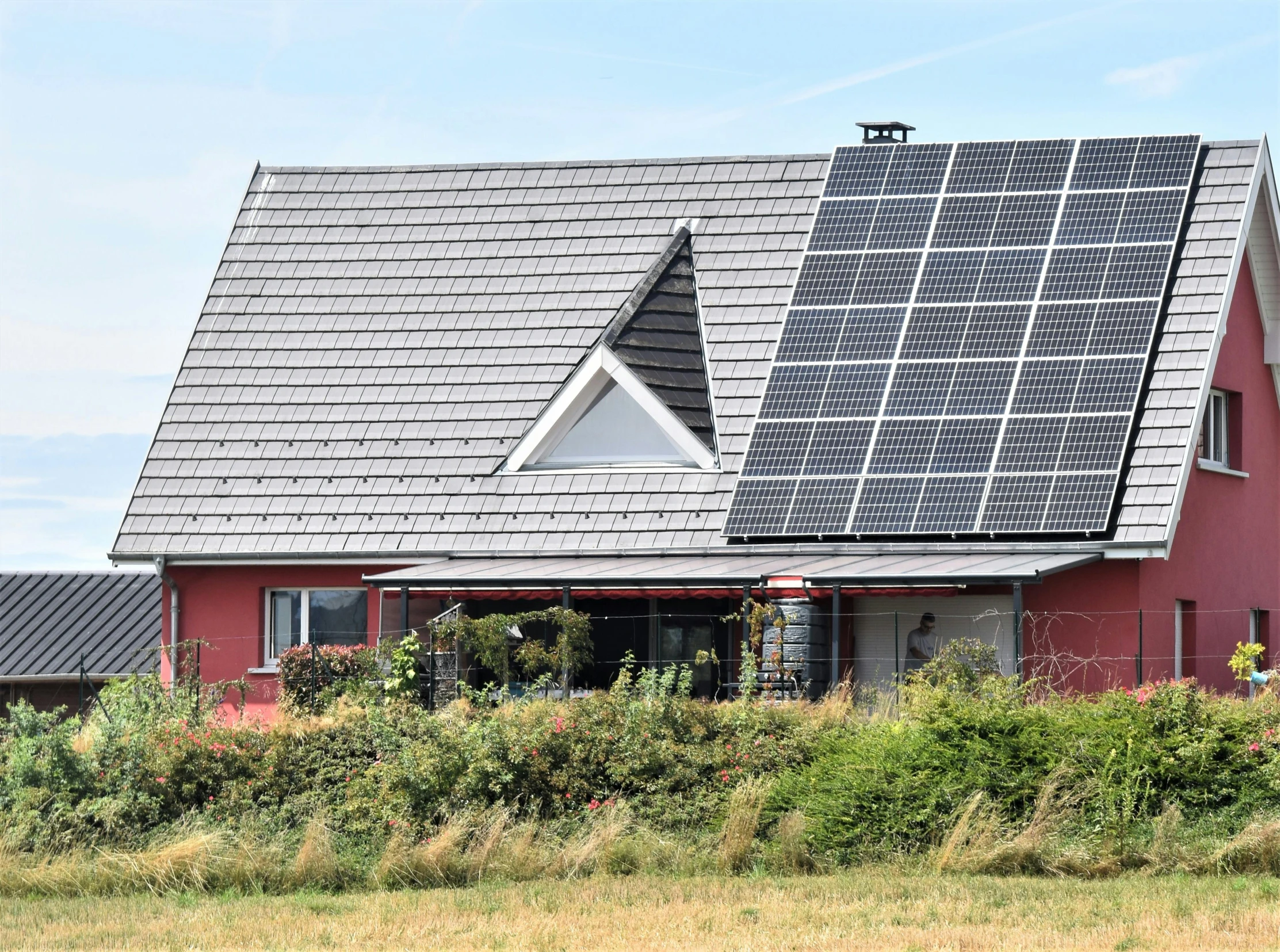 two small houses with red paint and solar panels on their roof