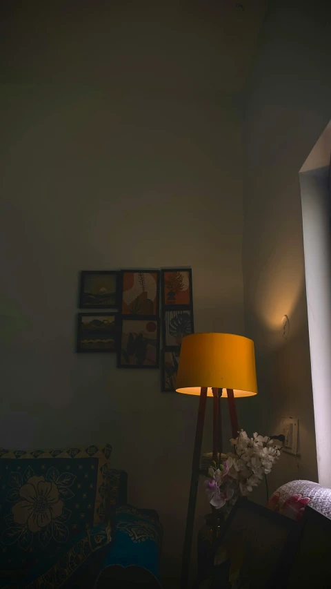 a lamp is lit in front of two paintings on the wall