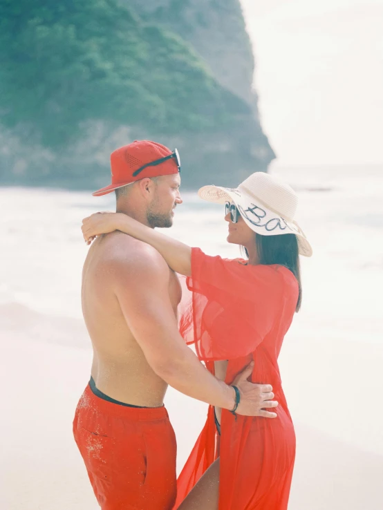 a man and woman are holding each other on the beach