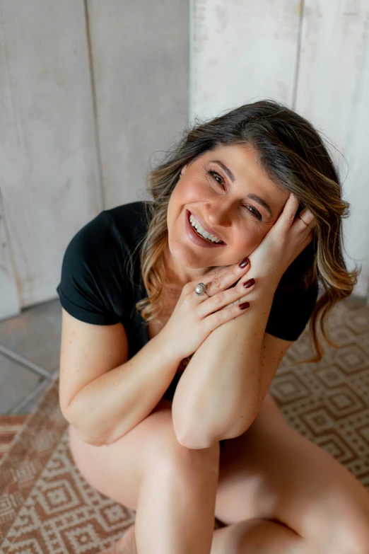 a  woman sitting on the floor with her hand resting on her knees