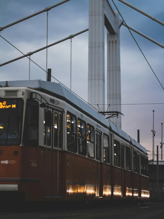 a train passes below a tall monument at dusk