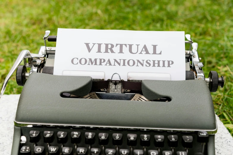 a black and white typewriter next to a green grassy field