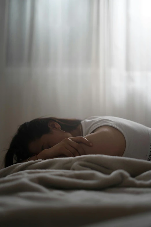 a person is laying on a bed in a dark room