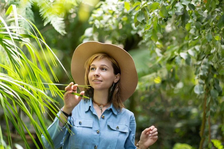 a woman in a hat with leaves and looking up