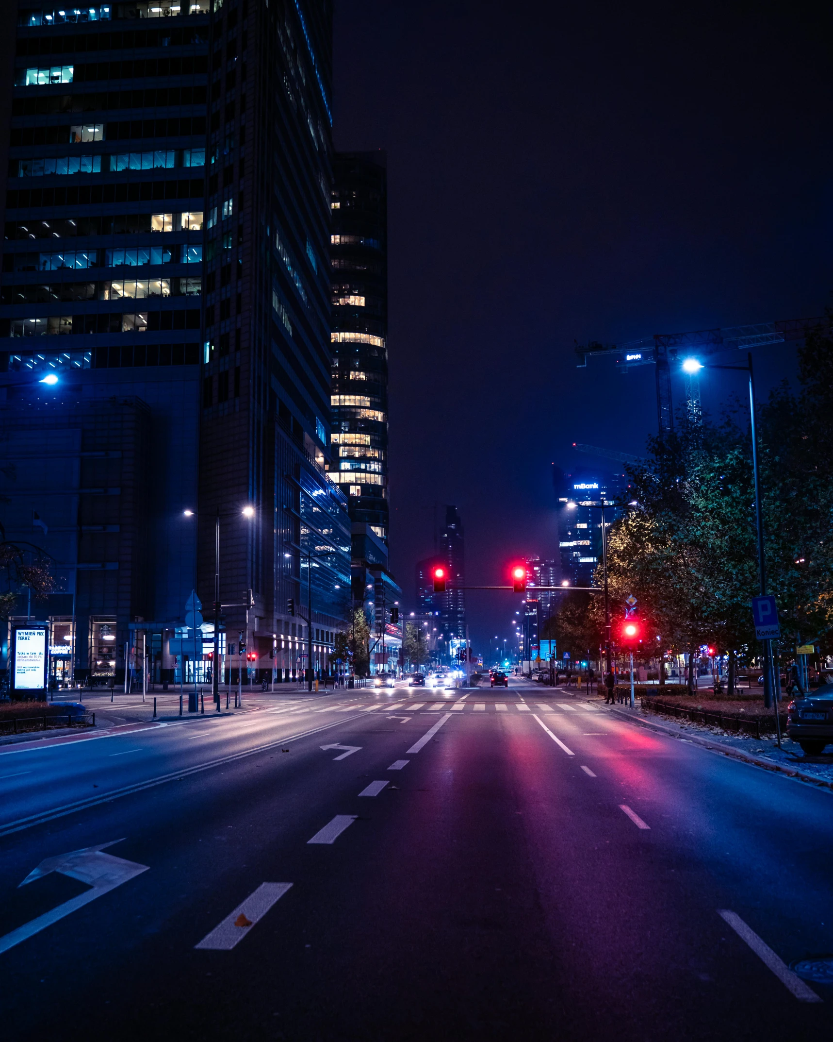 a city street with tall buildings lit up at night