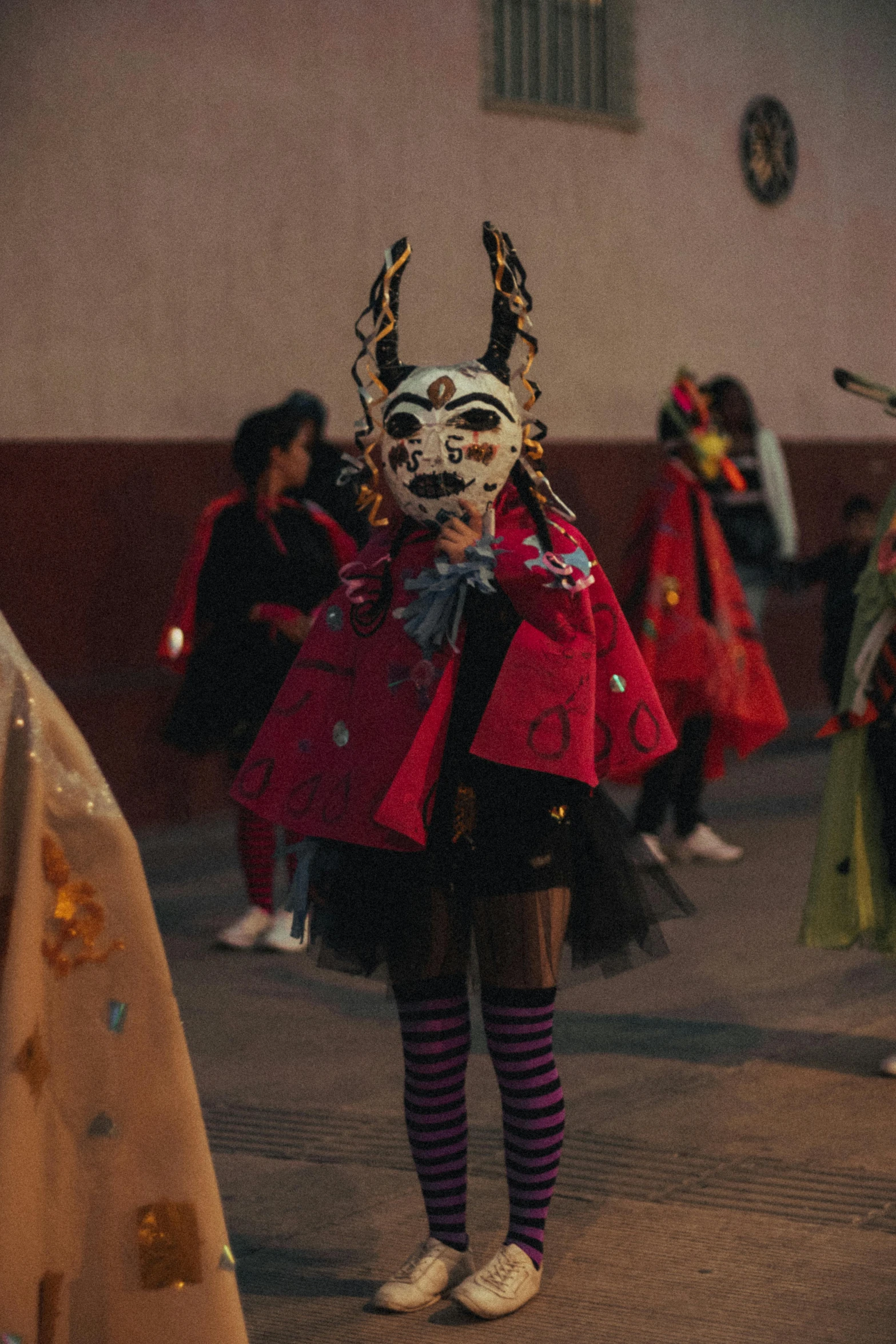 a person with a goat mask is standing by a wall