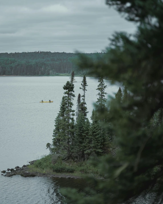 a lone boat in the middle of the lake on a small island