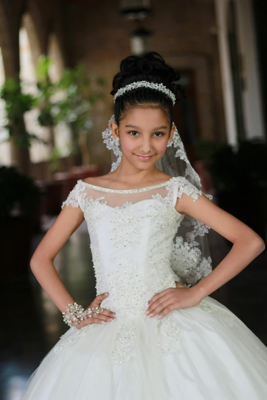 a girl is wearing a wedding dress and pearls and flowers