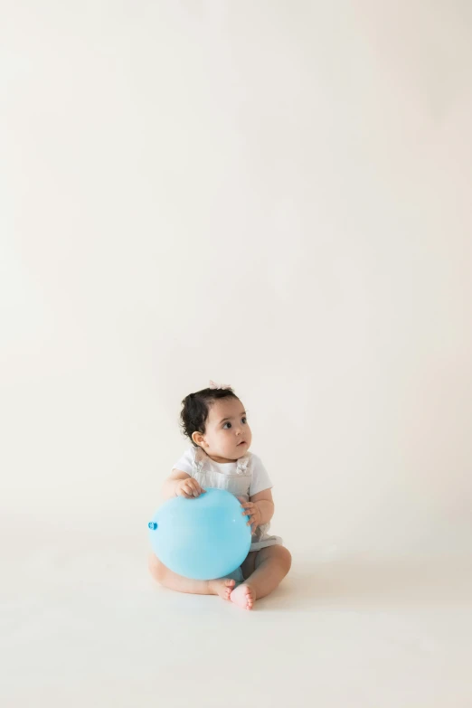 small child on the floor with a blue balloon