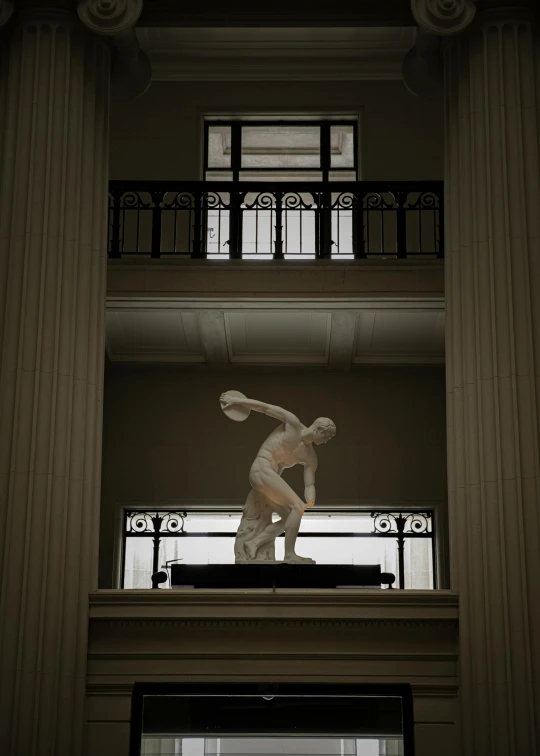 the statue is on a balcony near the columns