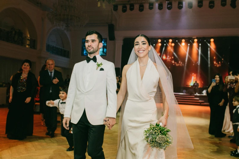 the newly married couple stands on the dance floor