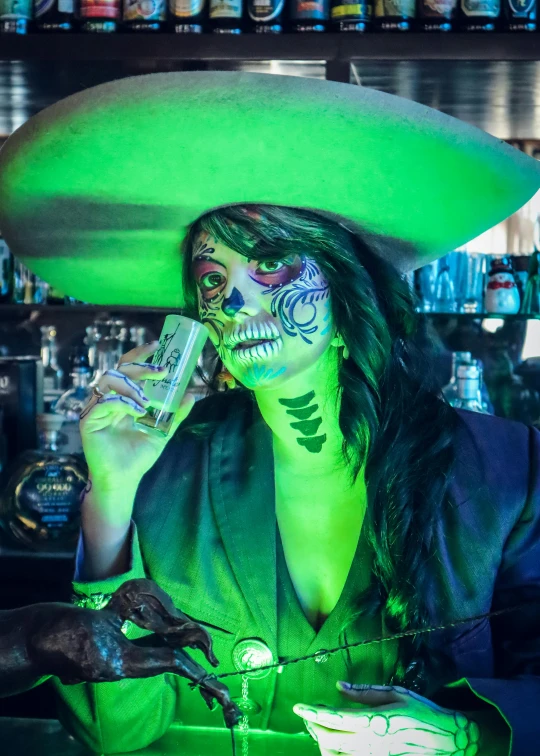 a woman in skull makeup drinking from a drink bottle