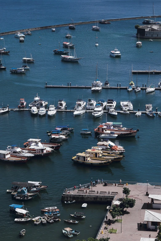 many boats are parked at the harbor next to a dock