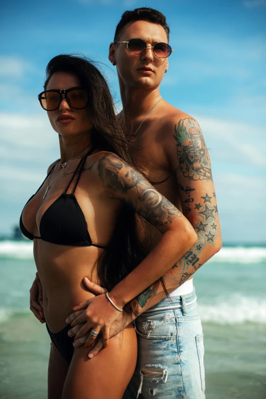 a couple posing for a po at the beach