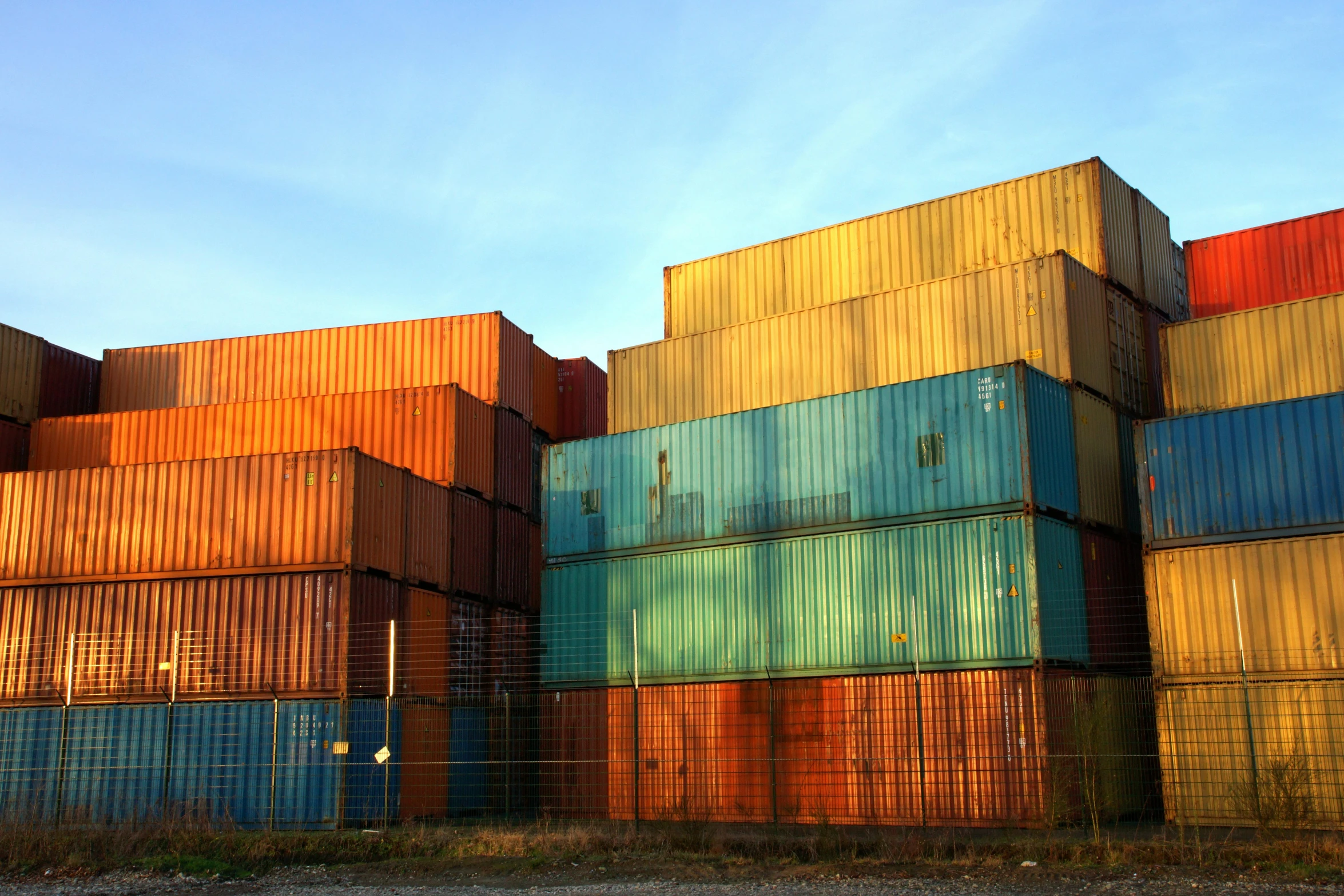 the stacked containers look very colorful against the sky