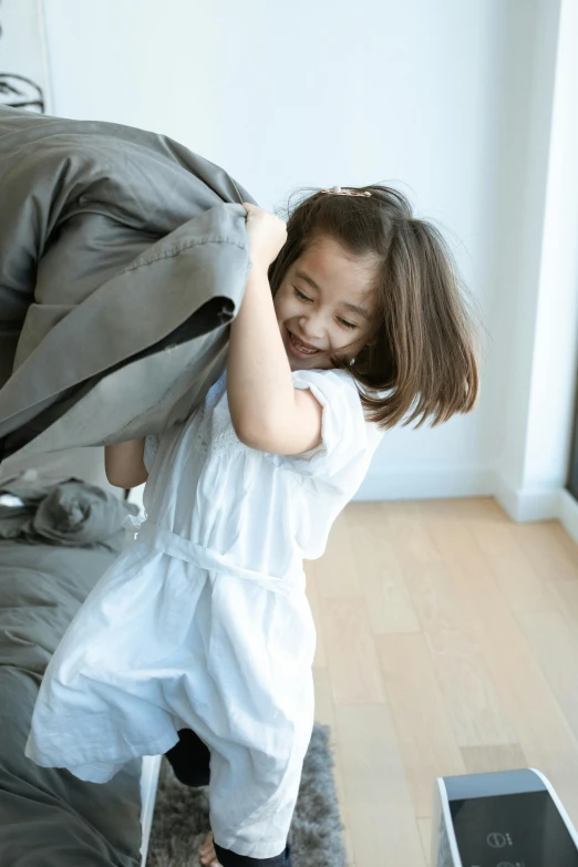 a little girl holding onto soing behind her back