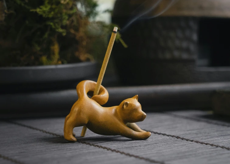 a small cat figurine is on top of a mat