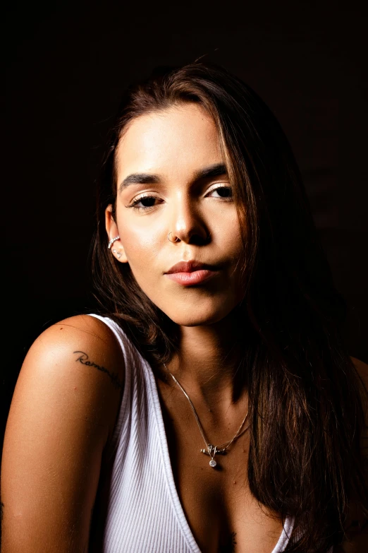 a young woman wearing a white top and a necklace