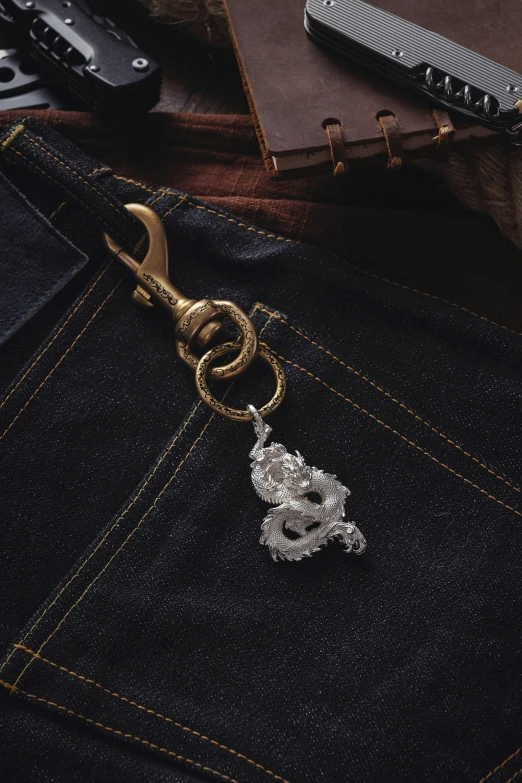 a golden snake is attached to a key chain on the back pocket of some jeans