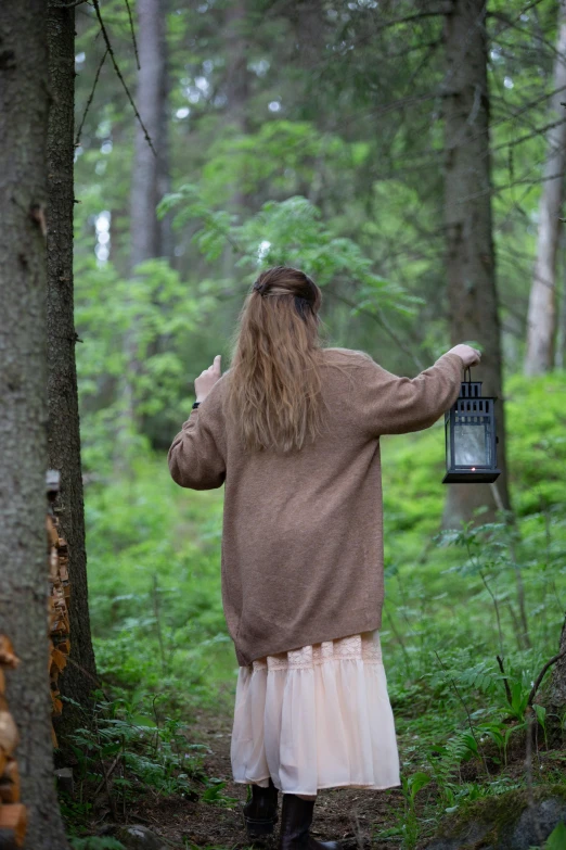 a person holding a lantern in the woods