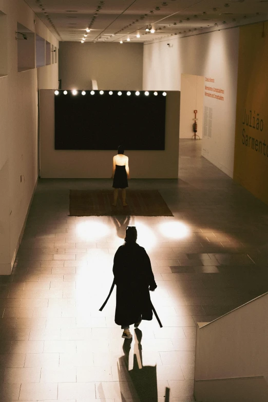 person walking down a set of stairs with lights on