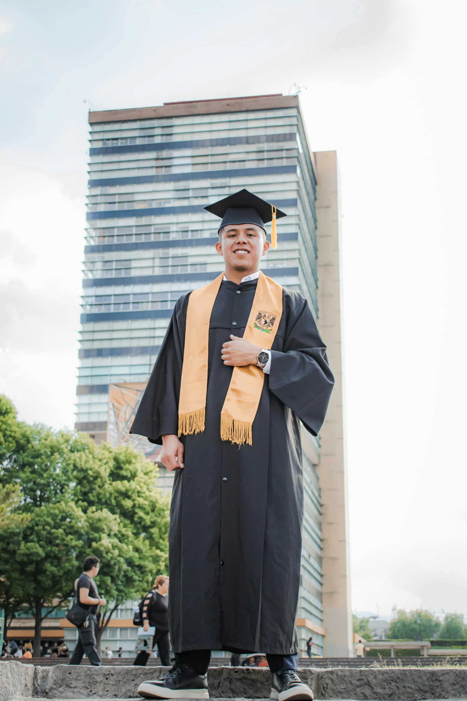 a man in graduation gown standing on a skateboard