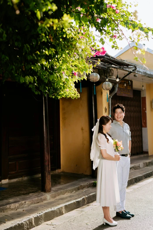 a young couple stands on steps in front of their home