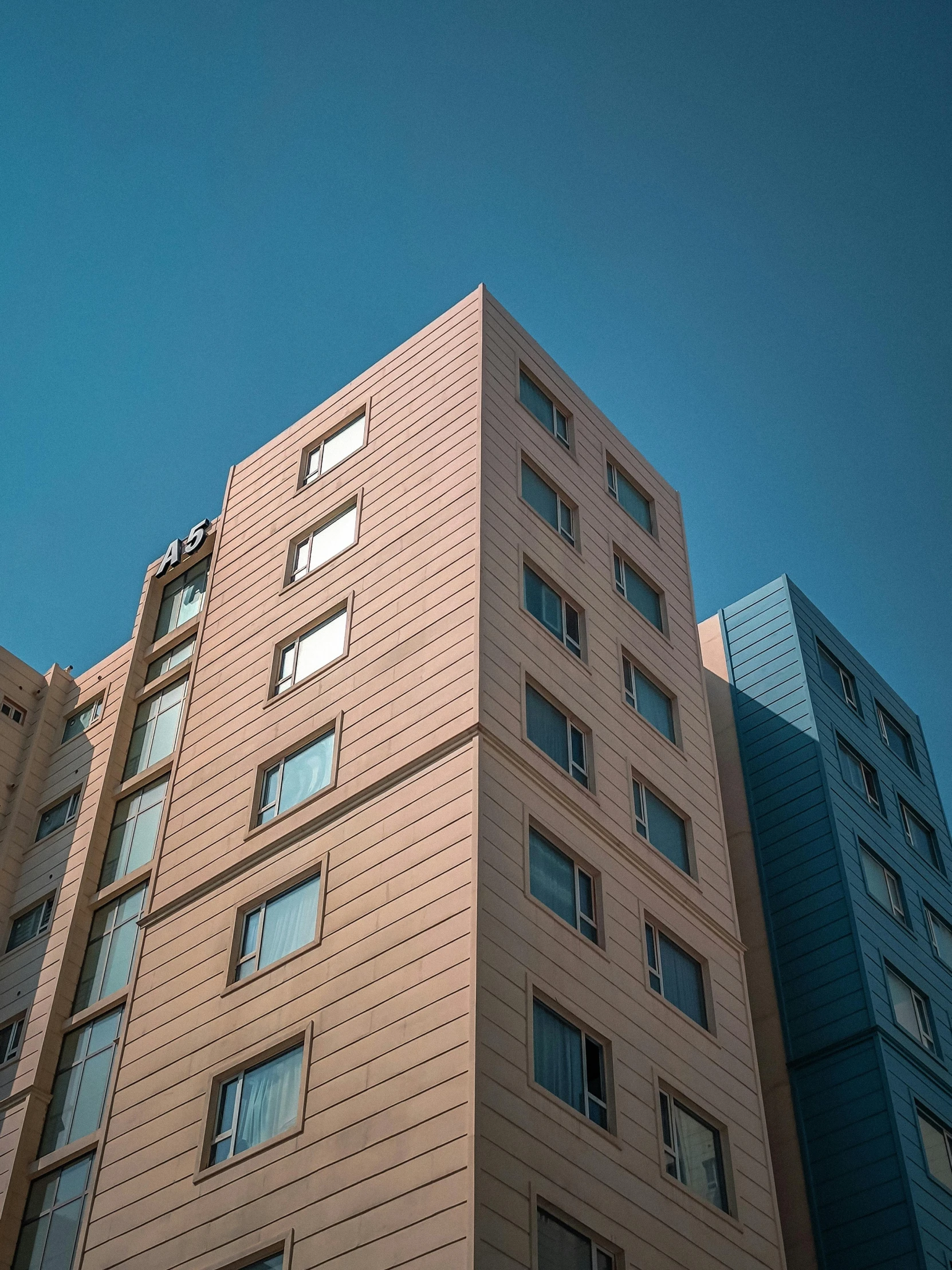 three large tall buildings in a blue sky