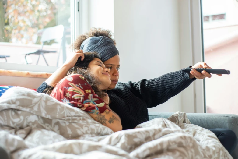 a woman and a child are sitting on a bed