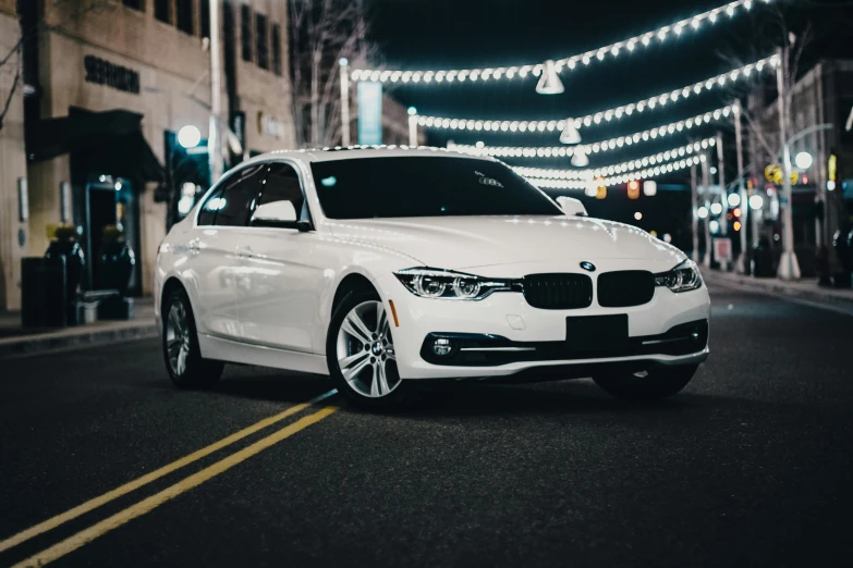 a white bmw is parked in the street