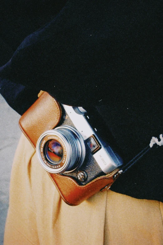 an old camera that is still attached to a hand held belt