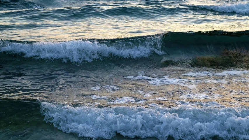 a very close up view of waves hitting the beach