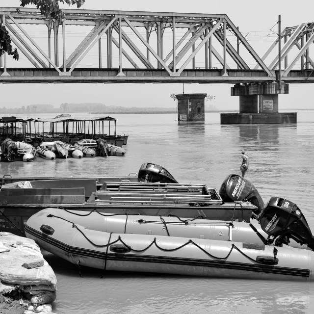 two boats docked in a harbor with an overpass