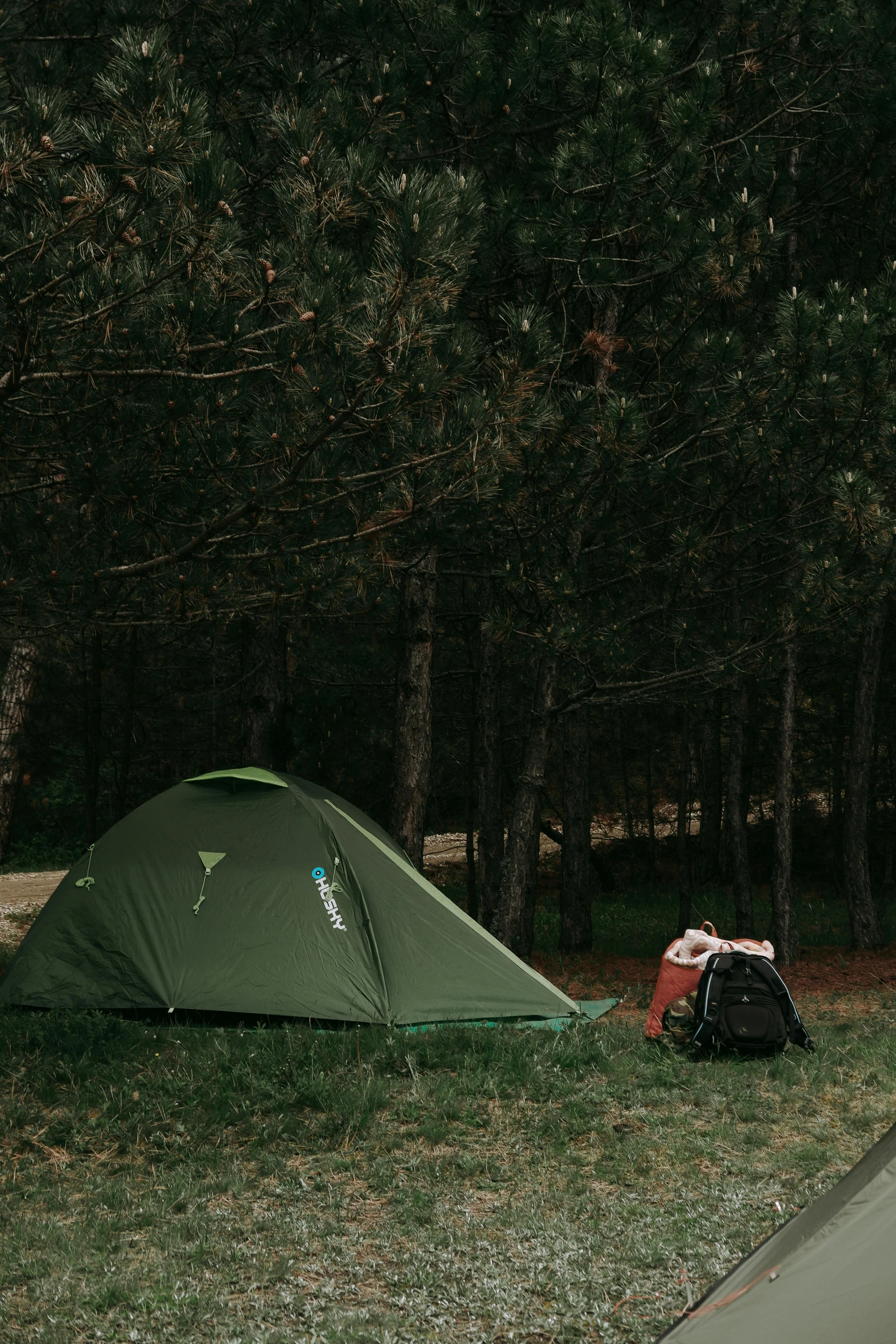 a camping site with tent and backpack in the foreground