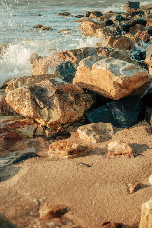 rocks and sand on the beach near the water