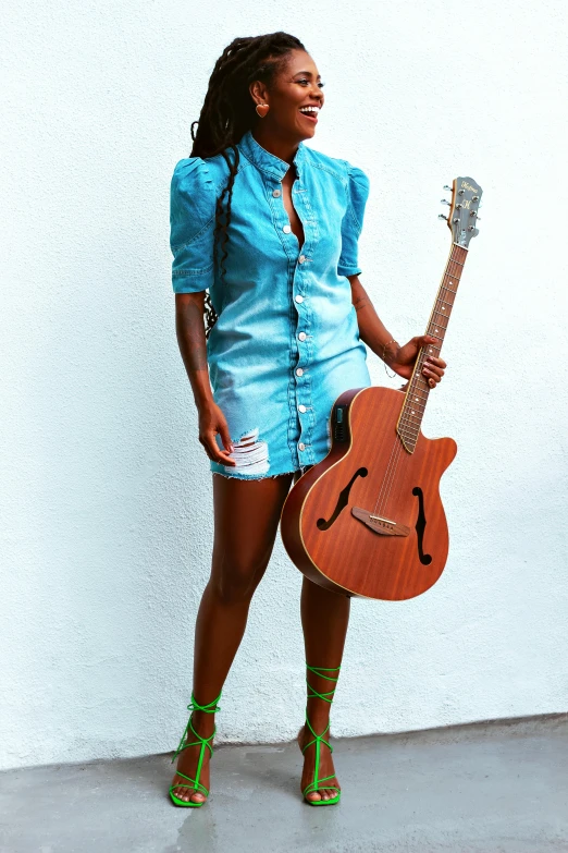 an african american girl wearing green heels, and playing a guitar