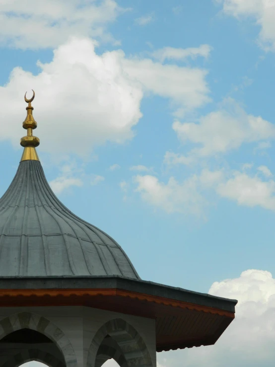 a dome with a clock on top sitting under the cloudy sky