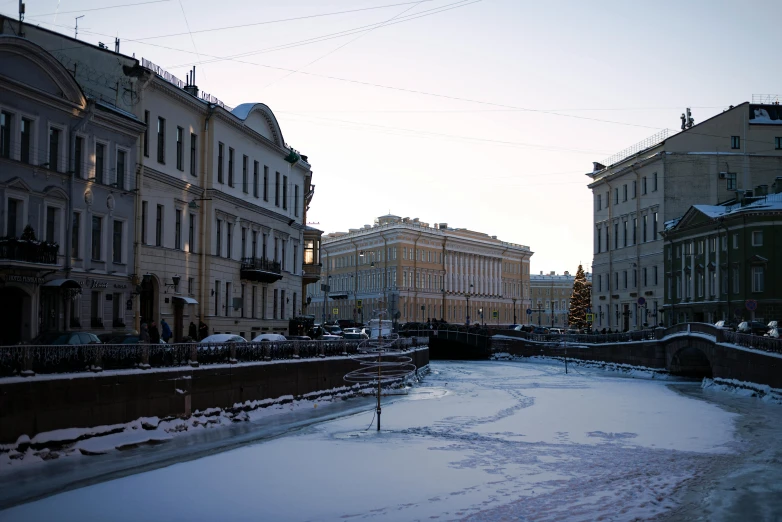 a canal with snow on it that is surrounded by old buildings
