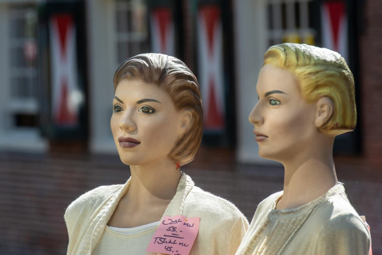 two mannequins are in front of a building