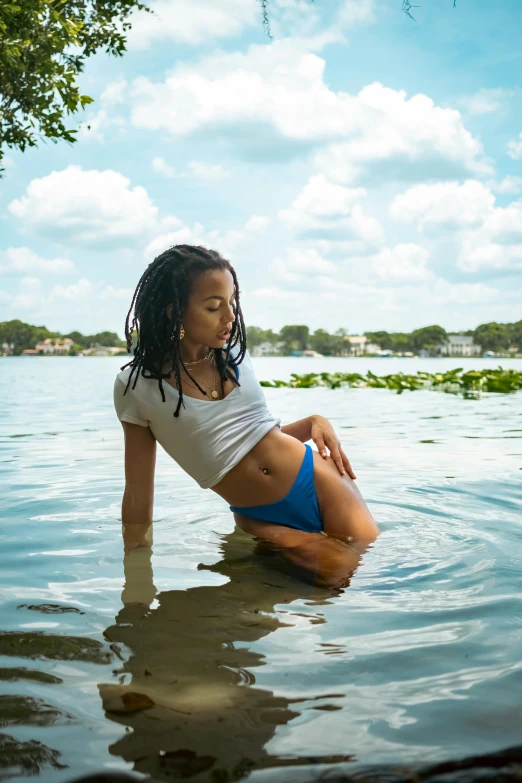 a young woman in a bikini is sitting in the water