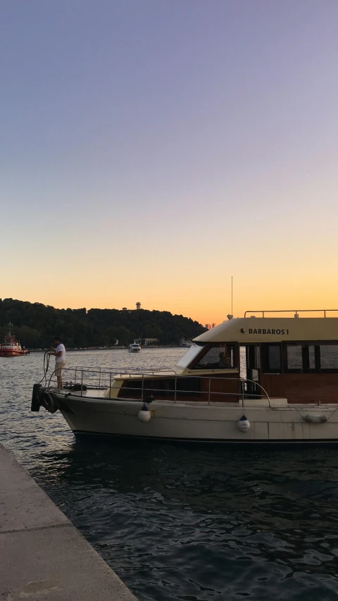 a boat sitting at a dock during the sun set