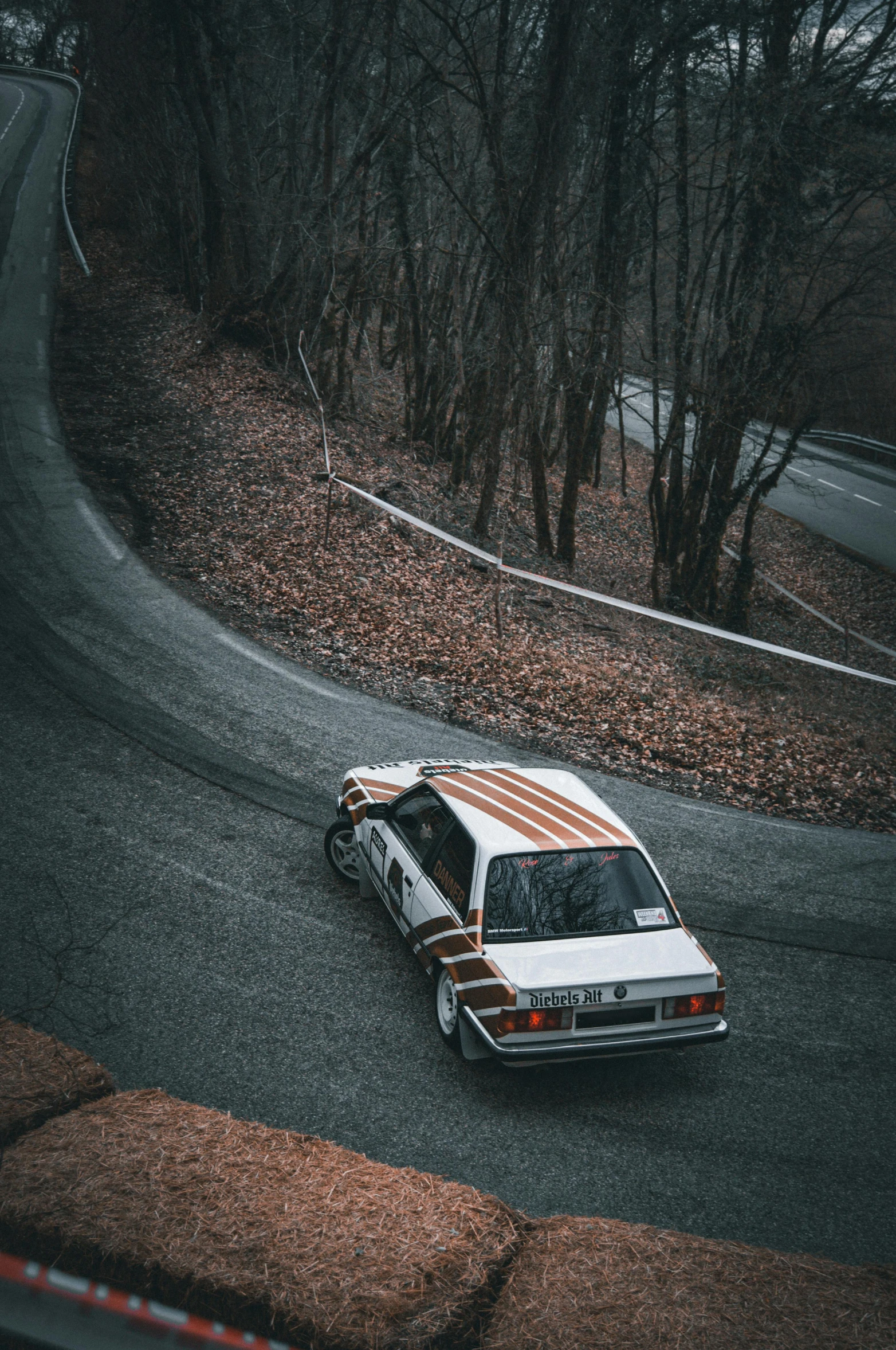 a car sits on a road next to some trees