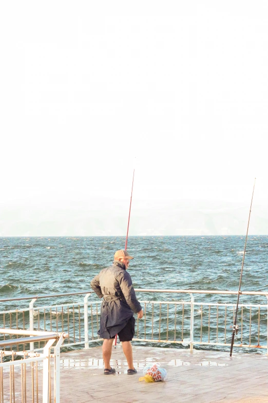 man standing on the pier while his dog watches