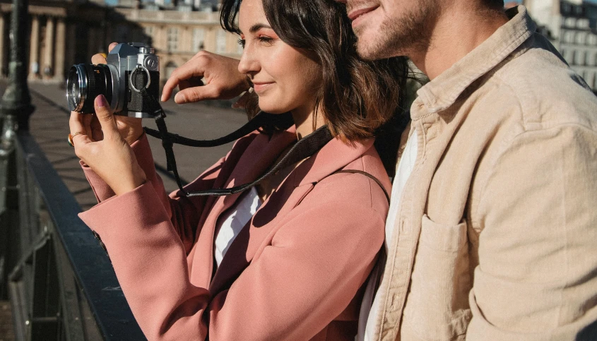 a man and woman are standing next to each other while taking pictures