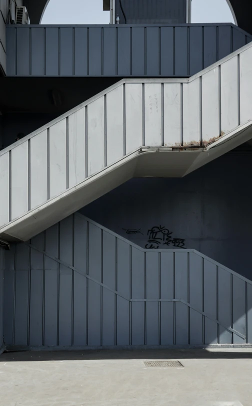 a concrete staircase is in between two grey structures