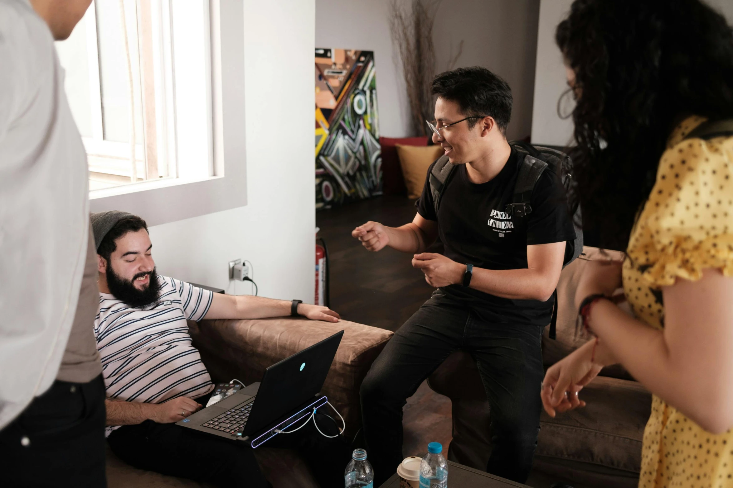 a man sits on a couch with three other people talking and laughing