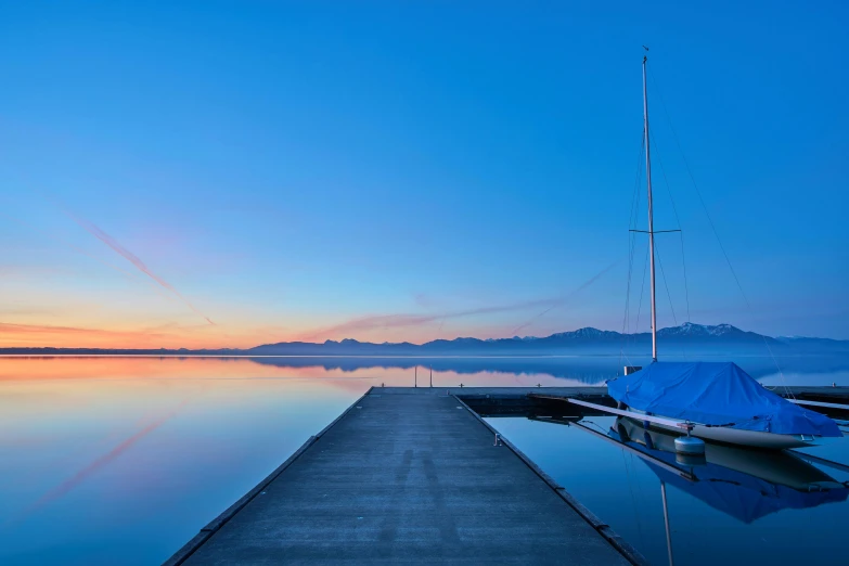 a dock in a body of water at sunset