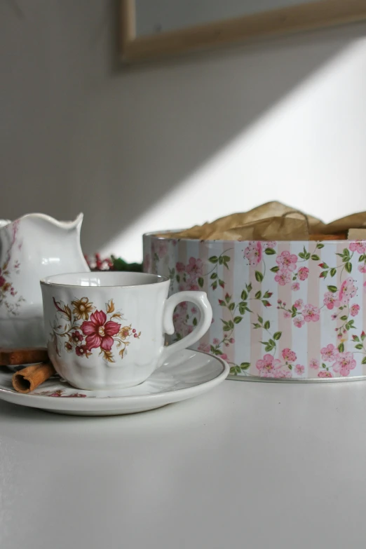 a cup and saucer sitting next to a box of cookies