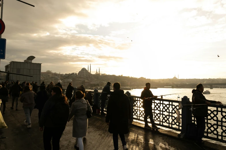 people walking along a bridge over the water